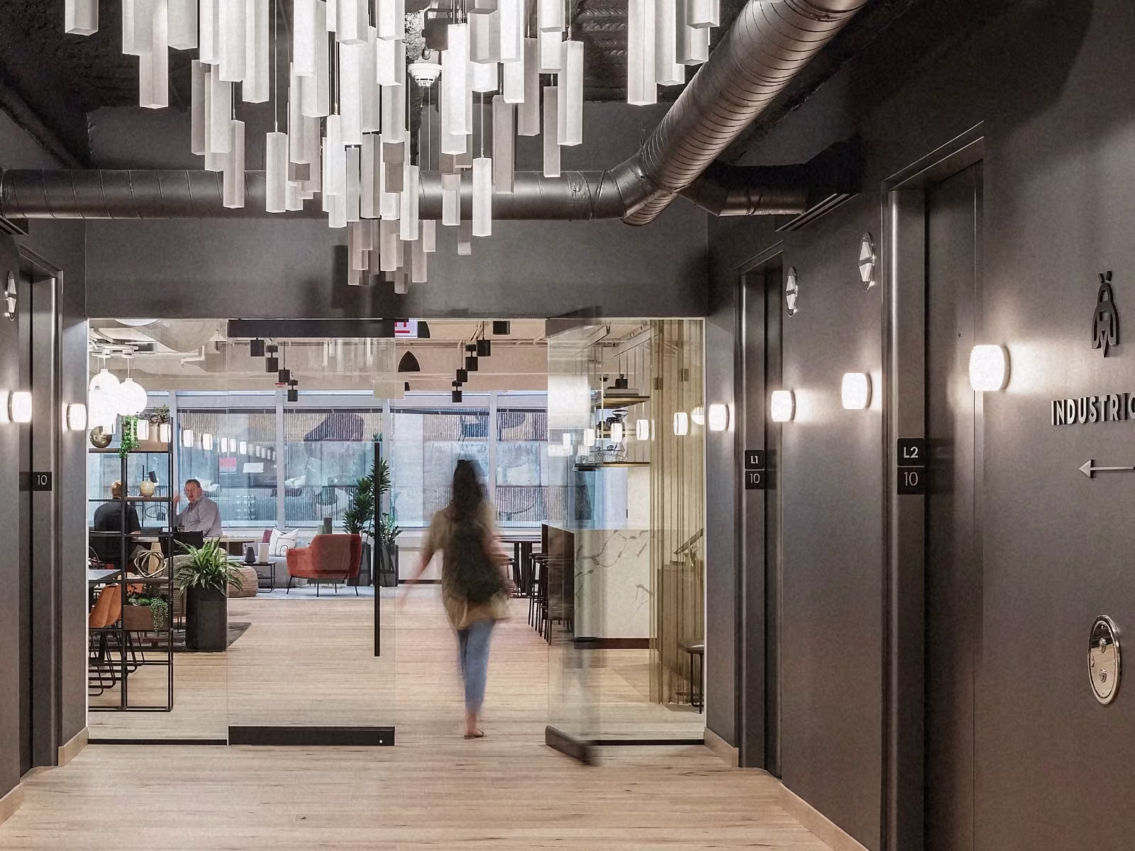 Industrious workspace graphic showing modern, light-filled coworking interiors.